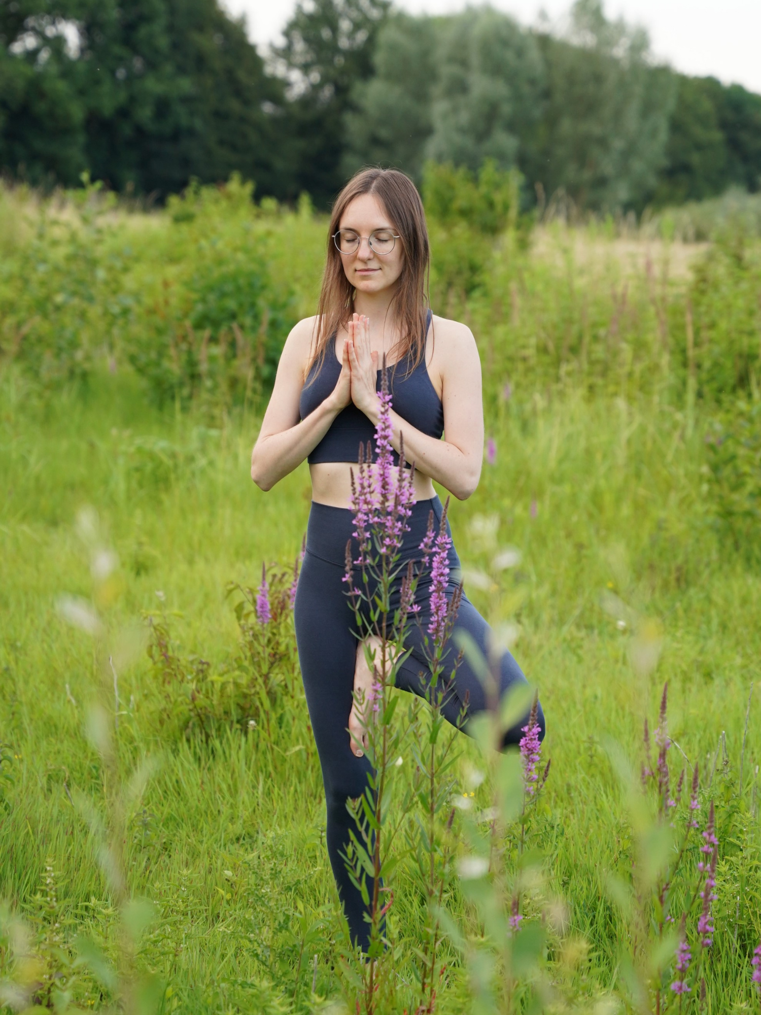 Deine Wegbegleiterin Tatjana in der Baumhaltung mit Anjali Mudra in der Natur