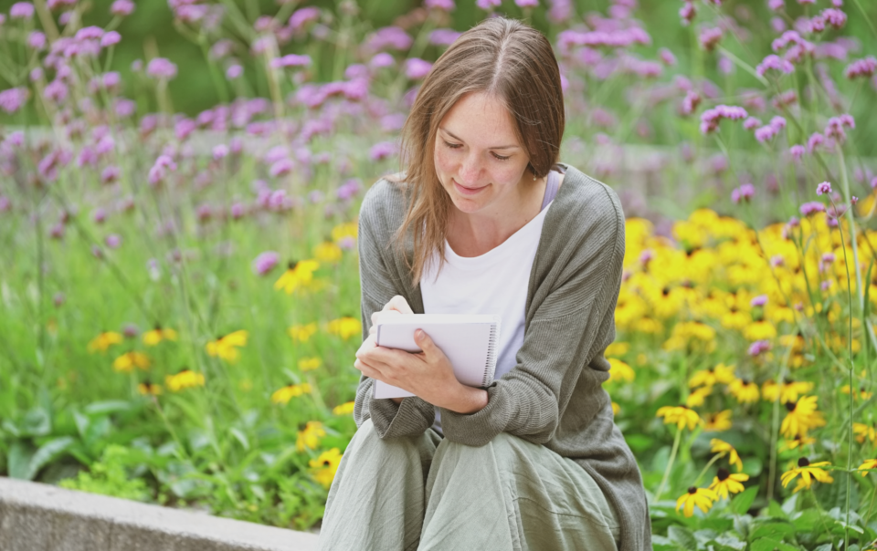 Tatjana, wie sie mit Stift und Notizbuch in den Händen ihre eigene Geschichte neu schreibt, authentisch, bewusst und selbstbestimmt