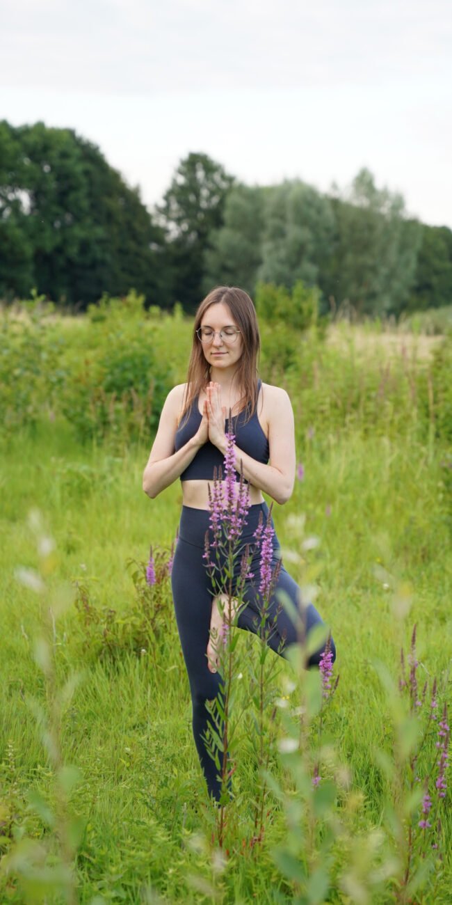Deine Wegbegleiterin Tatjana in der Baumhaltung mit Anjali Mudra in der Natur